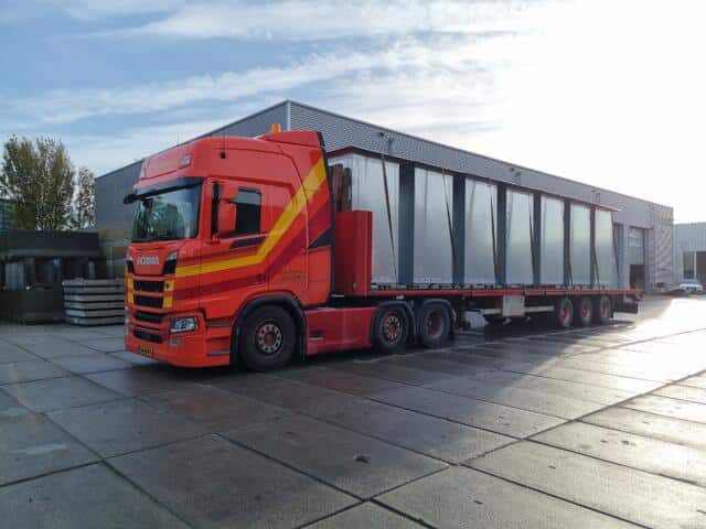 Vrachtwagen met oplegger. Plaatsen van afvalcontainers.
