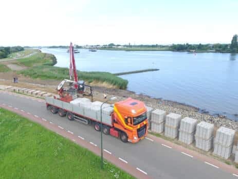 Vrachtwagen met betonproducten dijkversterking