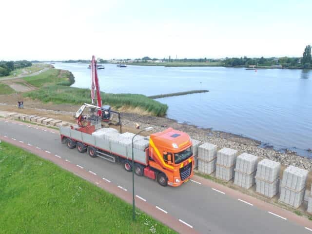 Vrachtwagen met betonproducten dijkversterking